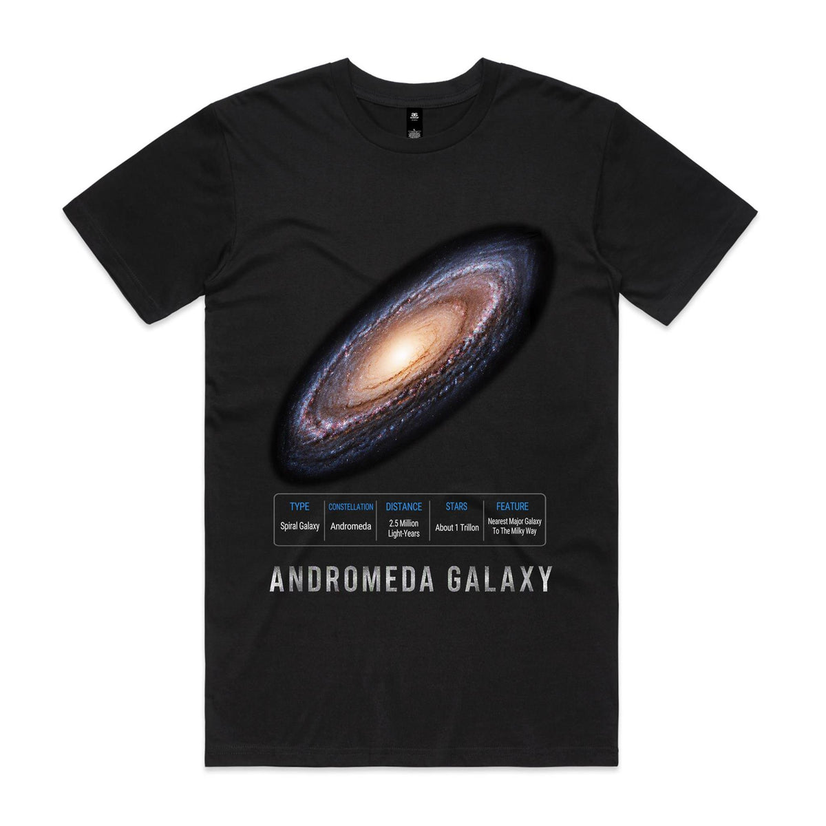 Front of Voltare Andromeda Galaxy black tee with a glowing cream-gold core, blue-violet spiral arms, galaxy-facts panel and silver-grey lettering
