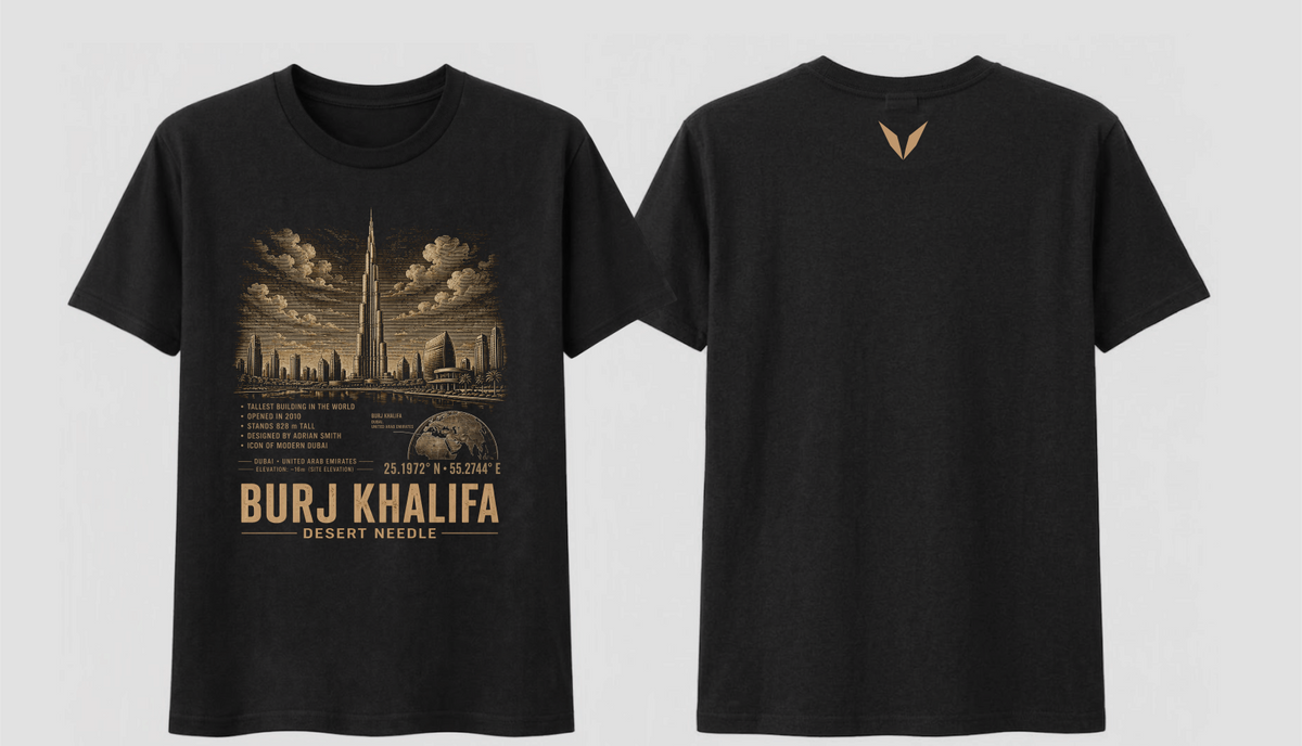 Front and back of the Black Voltare Burj Khalifa Desert Needle tee, showing tower and Dubai skyline artwork above facts, a map, coordinates and landmark lettering, with a small warm gold Voltare V high on the back