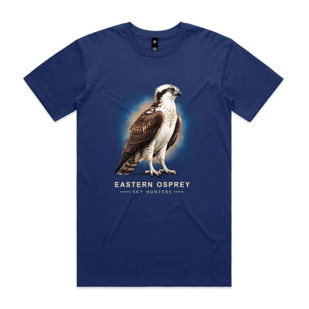 Front of the cobalt Voltare Eastern Osprey Sky Hunters T-shirt with an illustrated osprey featuring a pale chest, dark eye stripe and brown wings against a blue-and-sand backdrop.