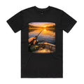 Front of the Black Voltare Golden Hour Boat Fishing tee with first-person boat fishing artwork over still water at sunset